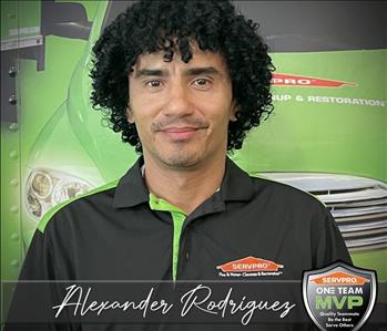 A SERVPRO Employee in front of a SERVPRO themed graphic on trailer